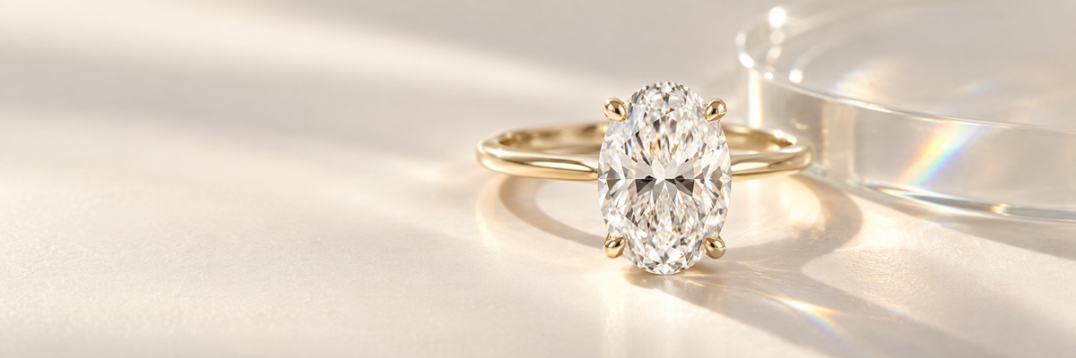 Oval white diamond engagement ring in yellow gold with subtle glass light effect