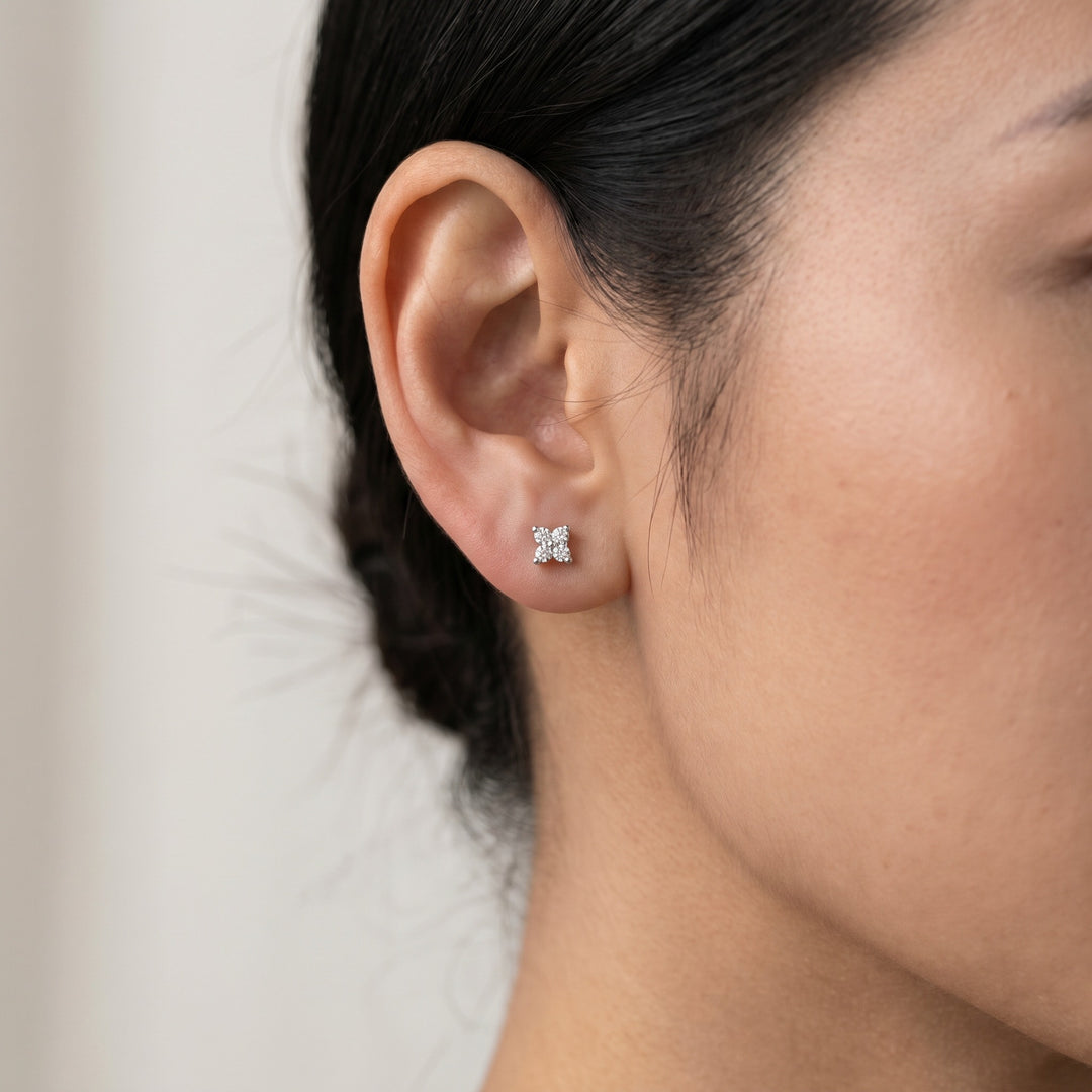 Delicate natural diamond flower stud earring in 14K white gold — worn on ear