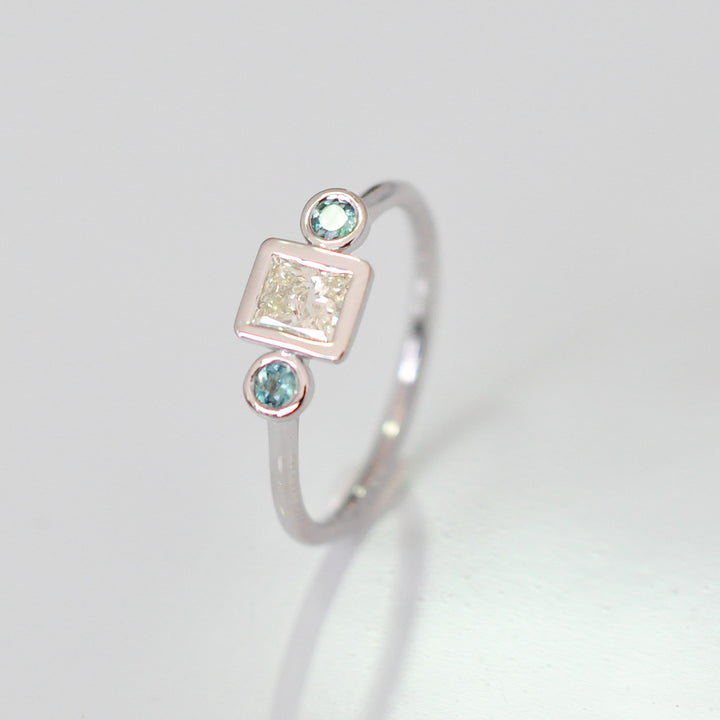 PRINCESS CUT diamond WITH two emeralds