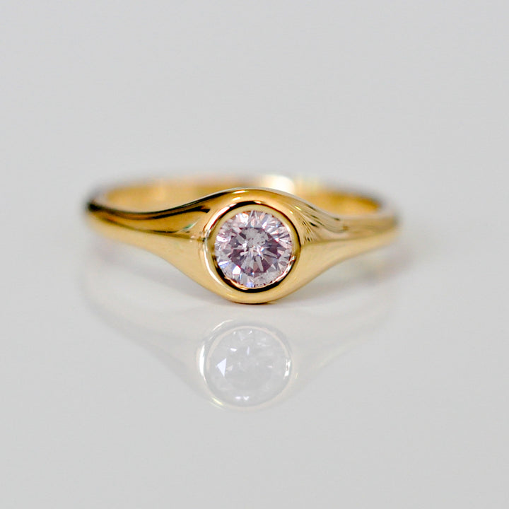Faint pink diamond bezel set yellow gold ring