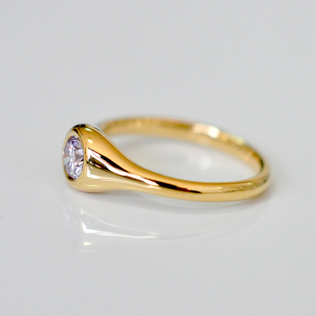 Faint pink diamond bezel set yellow gold ring
