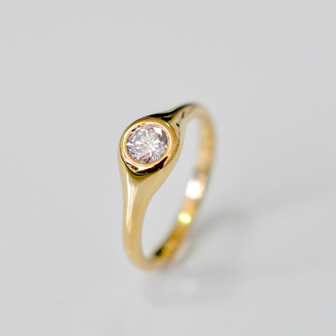 Faint pink diamond bezel set yellow gold ring